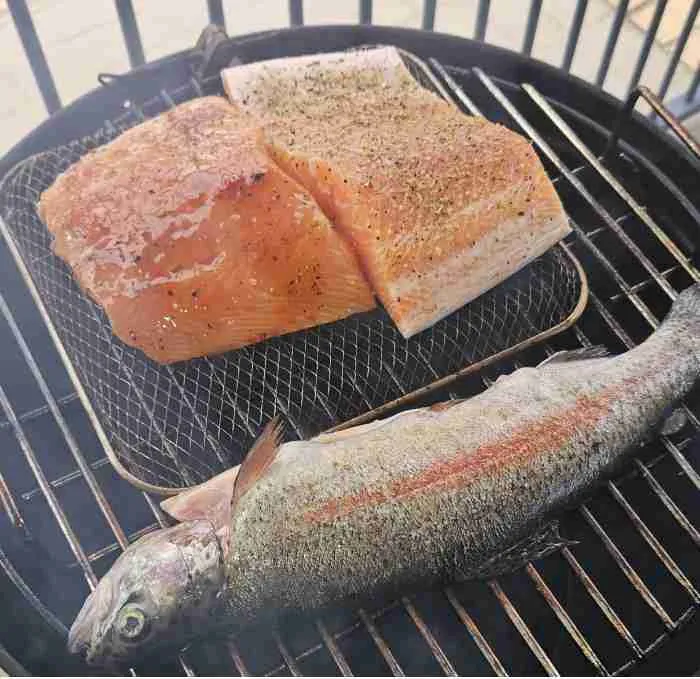 fishonsmoker1 Brined fish on a smoker grill, smoke rising gently.