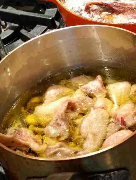 Fat-rendering A pot of chicken fat rendering on the stove, a crucial step in creating rich, flavorful bases for sauces and gravies, integral to gourmet cooking and enhancing depth in dishes.