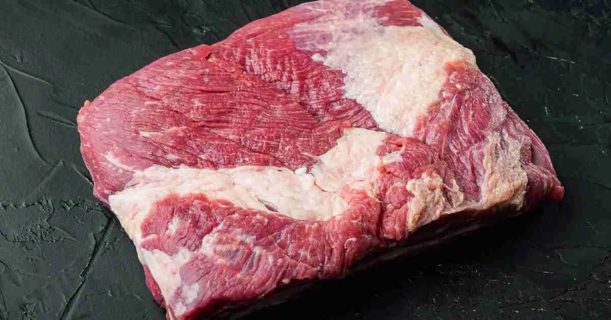 Trimmed-brisket Raw, partially trimmed brisket ready for smoking, displaying marbling and a thin layer of fat cap for flavor.