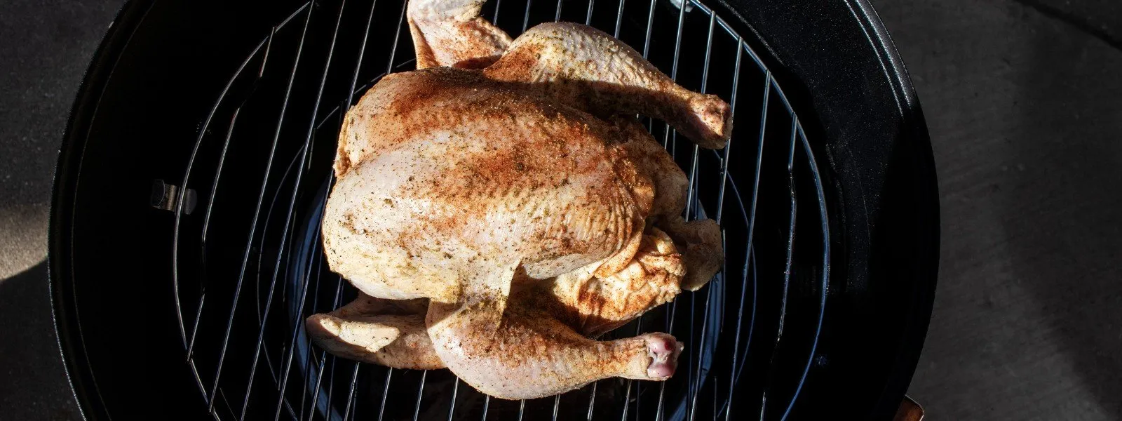 Whole-chicken-on-smoker Whole seasoned chicken on smoker grill ready for smoking.
