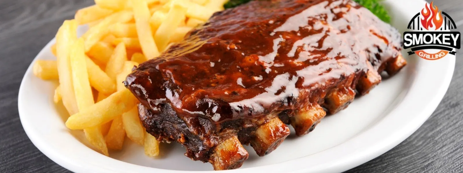 BBQ ribs with fries on a white plate.