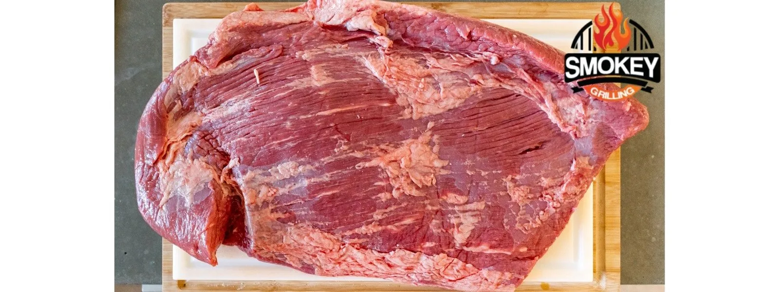 Raw-brisket-cutting-board Raw beef brisket on a cutting board.